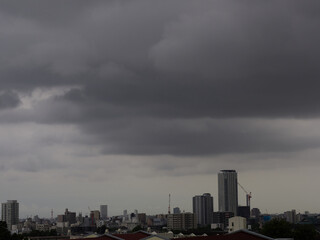 夏の日本の都市の上空の暗い雨雲の様子