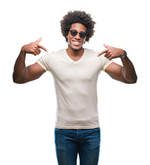 Afro american man wearing sunglasses over isolated background looking confident with smile on face, pointing oneself with fingers proud and happy.