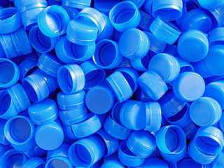 Top view blue plastic bottle caps.Recycling collection and production processing plastic bottle caps background ,Industrial production of bottle caps made of blue high-density polyethylene.