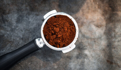 Top view of ground coffee in portafilter or portable coffee filter handle and ground coffee for a coffee making machine on coffee shop