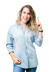 Obraz premium Beautiful young blonde woman over isolated background pointing finger up with successful idea. Exited and happy. Number one.