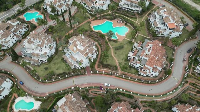 apartment buildings luxury property high end real estate prime location marbella spain downwards aerial drone shot swimming pool 