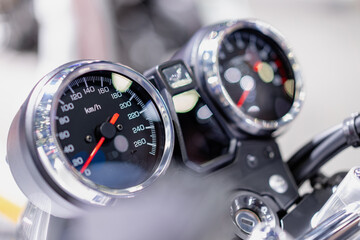 Side view of a black dial showing the speed of a vintage motorcycle