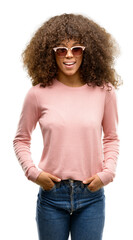 African american woman wearing pink sunglasses winking looking at the camera with sexy expression,...