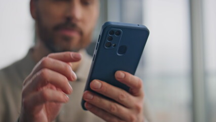 Bearded manager using mobile phone in morning closeup. Man hands typing screen