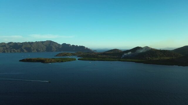 Wide aerial seascape near Banuang Daan and Bancuan Island in Coron Palawan Philippines with calm bay and hilly islets
