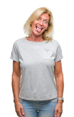 Fototapeta premium Middle age blonde woman over isolated background sticking tongue out happy with funny expression. Emotion concept.