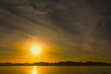 Golden Horizon: Sunset Over Ocean with Island Silhouette