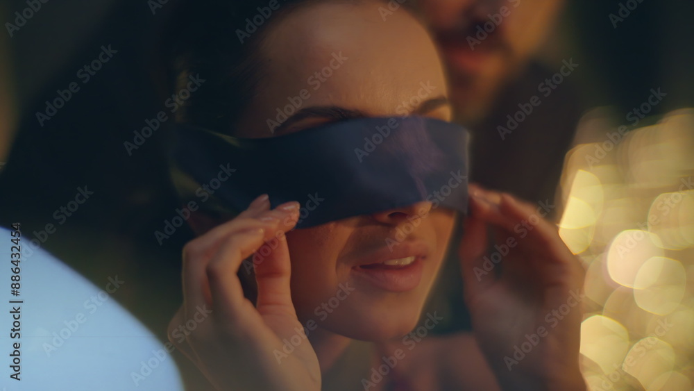 Wall mural woman removing eyes bandage reacting romantic surprise night atmosphere closeup