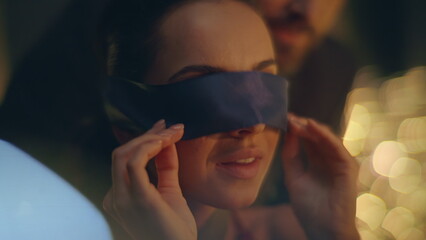 Woman removing eyes bandage reacting romantic surprise night atmosphere closeup
