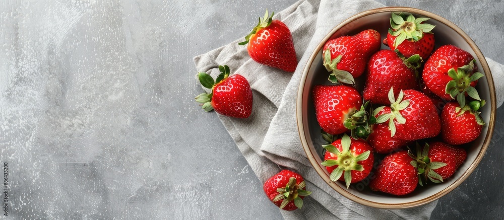 Aufkleber a vibrant red strawberry sits in a ceramic bowl on a linen napkin against a gray concrete background
