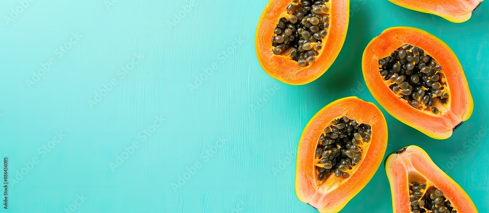 Aufkleber ripe papaya fruits on a light turquoise backdrop with a flat lay presentation and a copy space image