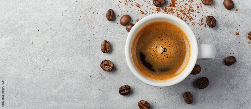 Poster flat lay photo of a cup of fresh espresso with coffee beans on a grey background ideal for a copy sp