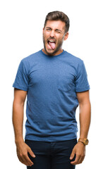 Obraz premium Young handsome man over isolated background sticking tongue out happy with funny expression. Emotion concept.