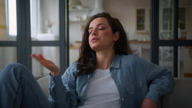 Overheated Caucasian woman on sofa couch wave hand refresh tired cool with arms unhappy sweaty lady girl female suffer of high temperature problem feel sweat at hot living room without air conditioner