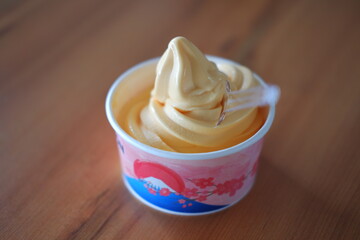 ice cream in paper cup on wood table background. soft focus.