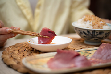 鰹のお刺身を食べる女性の手元
