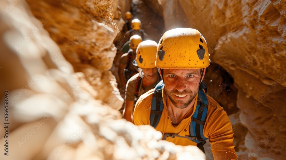 Wall mural helmeted explorers navigate through a narrow canyon bathed in sunlight, emphasizing teamwork and adv