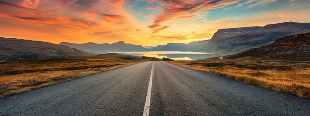 Obraz premium Asphalt Road Through a Mountain Landscape at Sunset