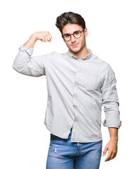 Young handsome man wearing glasses over isolated background Strong person showing arm muscle, confident and proud of power