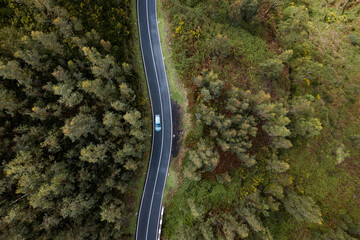 Family car moving in mountain landscape on Madeira island, aerial shot. Transportation, car rental, insurance concept