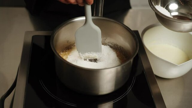A confectioner melts sugar in a pan to prepare caramel. Making caramel at home. Concept of confectionery and cakes