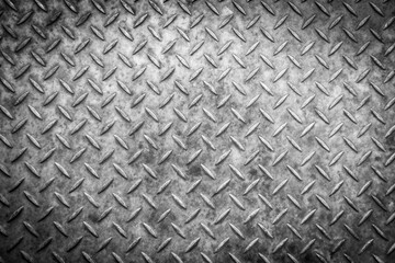 A close up of a metal surface featuring a diamond pattern