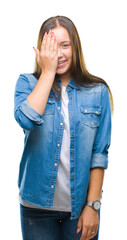 Young caucasian beautiful woman over isolated background covering one eye with hand with confident smile on face and surprise emotion.