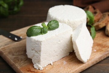 Fresh ricotta (cream cheese) and basil on table, closeup