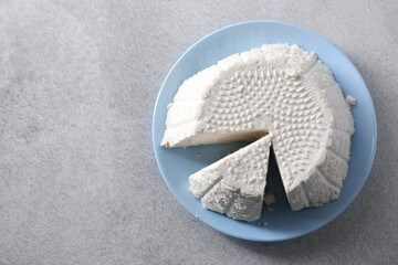 Tasty ricotta (cream cheese) on grey table, top view. Space for text