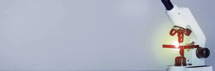 Microscope on grey background, closeup. Banner design with space for text