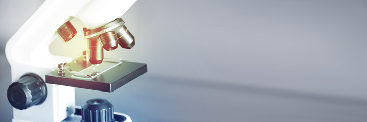 Microscope on blurred background, closeup. Banner design with space for text