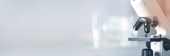 Microscope on blurred background, closeup. Banner design with space for text