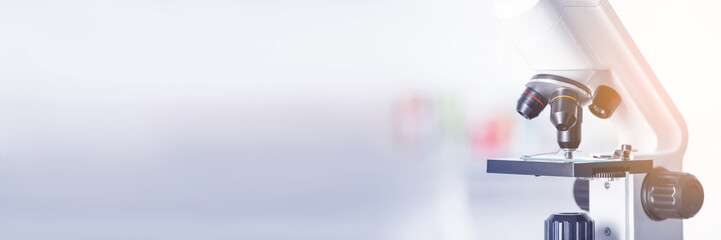 Microscope on blurred background, closeup. Banner design with space for text