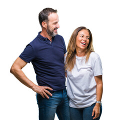 Middle age hispanic casual couple over isolated background looking away to side with smile on face, natural expression. Laughing confident.