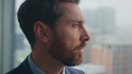 Thoughtful man contemplating gloomy cityscape closeup. Smiling boss resting
