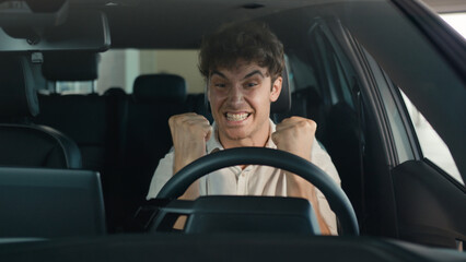 Smiling positive successful happy Caucasian man excited with new luxury car make winner hands...