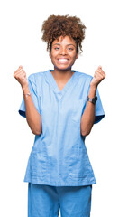 Young african american doctor woman over isolated background celebrating surprised and amazed for success with arms raised and open eyes. Winner concept.