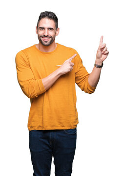 Young handsome man over isolated background smiling and looking at the camera pointing with two hands and fingers to the side.