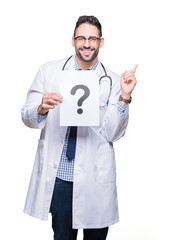 Handsome young doctor man holding paper with question mark over isolated background very happy pointing with hand and finger to the side