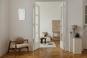 Cozy, minimalist living space with a mid-century modern armchair, soft lighting, and neutral tones....