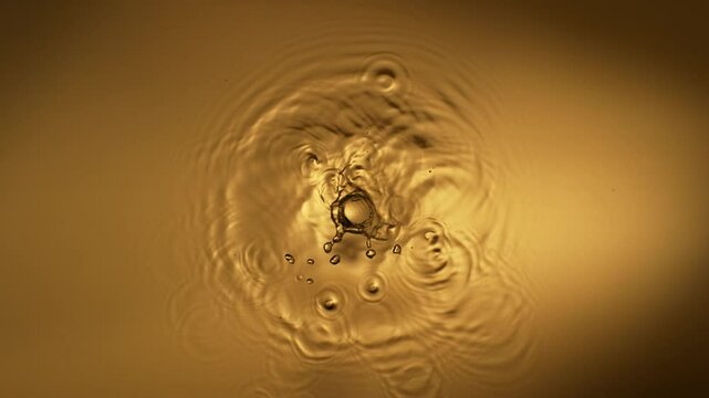Super Slow Motion of Splashing Liquid on Golden Background , Filmed on High Speed Cinematic Camera at 1000 FPS