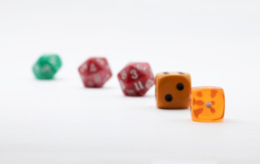 dadi da gioco di varie forme e colori su superficie e sfondo bianco