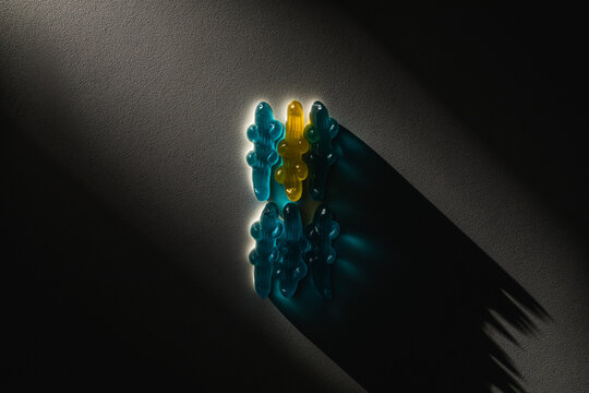 concetto di unico tra i tanti, essere diversi, essere quello diverso nel gruppo. file di caramelle blu di cui soltanto una gialla, illuminate da un fascio di luce