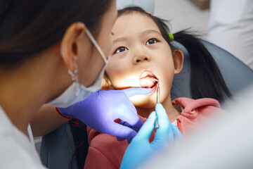 Child Girl Undergoing Routine Dental Check-Up With Female Dentist in Clinic