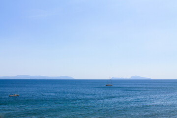 Two sailboats on the sea on the mountains background in Italy, the Bay of Naples