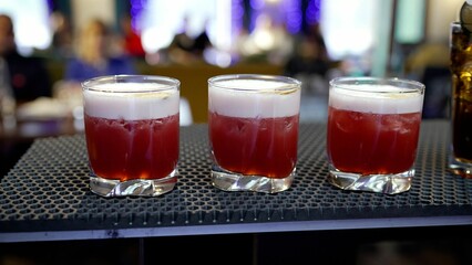 Glasses with an alcoholic cocktail, 3 pieces, stand on the bar counter, close-up.