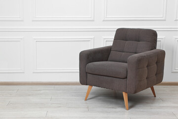One soft armchair near white wall indoors. Space for text