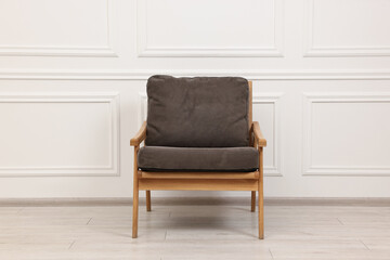 One comfortable soft armchair near white wall