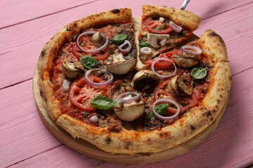 Tasty pizza with mushrooms, basil and tomatoes on pink wooden table, closeup
